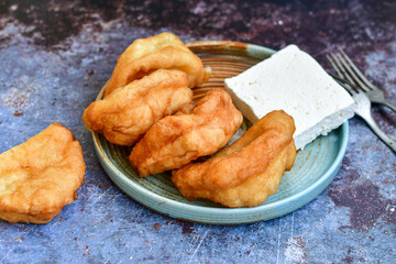 Traditional Bulgarian home made deep fried  patties  covered with sugar  оn rustic backgroud.Mekitsa or Mekica,  on wooden  rustic  background. Made of kneaded dough that is deep fried 