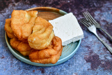 Traditional Bulgarian home made deep fried  patties  covered with sugar  оn rustic backgroud.Mekitsa or Mekica,  on wooden  rustic  background. Made of kneaded dough that is deep fried 