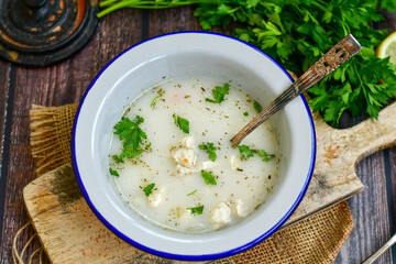 Home made chicken soup with noodles ,parsley and vegetables in white bowl . Healty soup