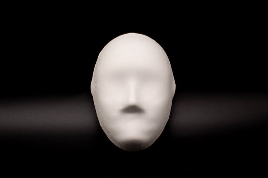 white Venetian mask on a black background. The concept of the theater