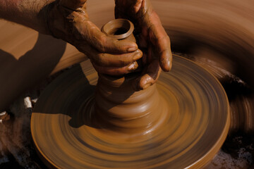 Potter modeling of clay on a potter's wheel In the pottery shop, Maharashtra, India.