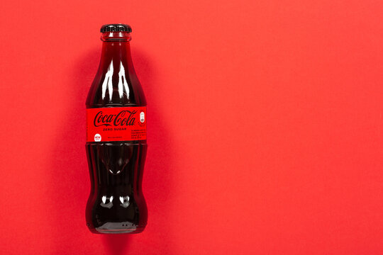 Ternopil, Ukraine - December 30, 2021: A bottle of Coca-Cola Zero Shugar on a red background