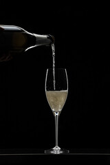 Pouring champagne in glass graphically presented in studio setting