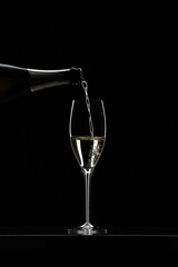 Pouring champagne in glass graphically presented in studio setting