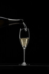 Pouring champagne in glass graphically presented in studio setting