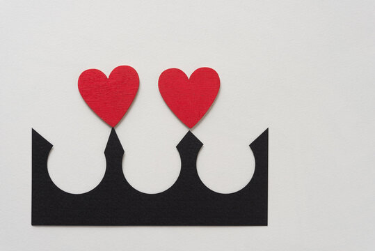 two wooden hearts painted red with black paper shape