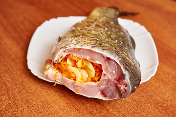 Cooking fish stuffed with carrots and onions.