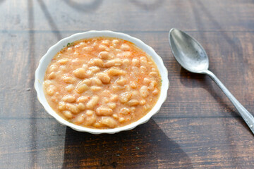   Homemade bean soup .Steamed white beans in tomato sauce  on a wooden background  