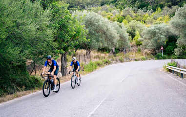 Two cyclists training on a mountain road. Cycling image with copy space. Healthy concept