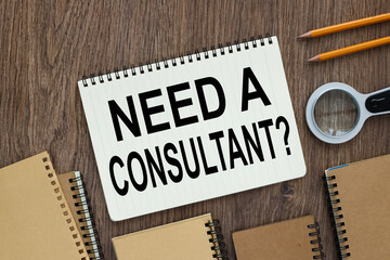Need a consultant? Open notebooknear a magnifying glass and pencils on wooden desk