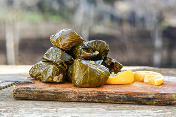 Dolmades - stuffed grape leaves  rolls  with rice the Greek way on wooden table .Stuffed greek wine...