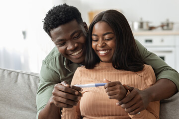 Married black couple happy with positive results of pregnancy test