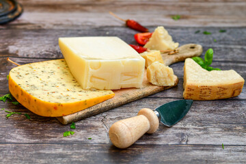  Set of different kinds ot delicious   Italian hard  cheeses,  cheese knives  and walnuts on wooden cheese board.Parmesan. Top view.