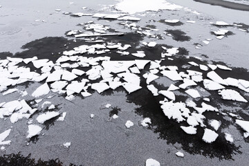 Pieces of thin ice, water freezing on a cold winter day.