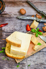  Set of different kinds ot delicious   Italian hard  cheeses,  cheese knives  and walnuts on wooden cheese board.Parmesan. Top view.