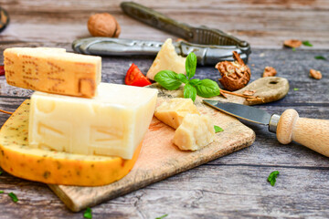  Set of different kinds ot delicious   Italian hard  cheeses,  cheese knives  and walnuts on wooden cheese board.Parmesan. Top view.