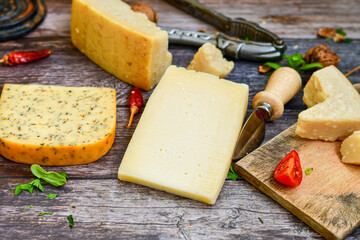  Set of different kinds ot delicious   Italian hard  cheeses,  cheese knives  and walnuts on wooden cheese board.Parmesan. Top view.