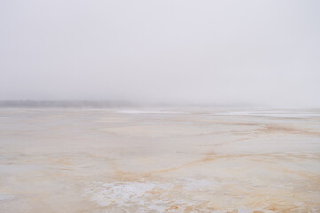 Abstract misty serene winter scene over frozen lake. Blurred background. Defocused image