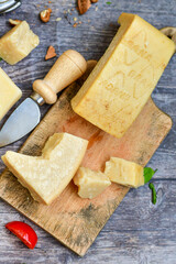  Set of different kinds ot delicious   Italian hard  cheeses,  cheese knives  and walnuts on wooden cheese board.Parmesan. Top view.