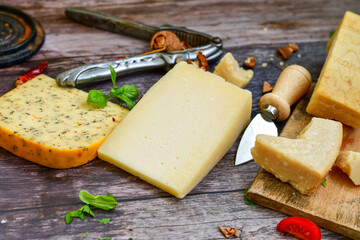 Set of different kinds ot delicious   Italian hard  cheeses,  cheese knives  and walnuts on wooden cheese board.Parmesan. Top view.
