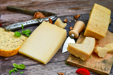  Set of different kinds ot delicious   Italian hard  cheeses,  cheese knives  and walnuts on wooden cheese board.Parmesan. Top view.