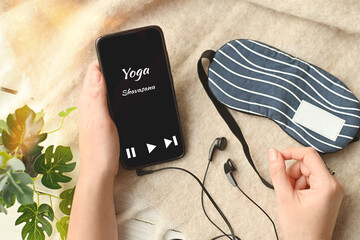 An application for meditation and stress relief. Yoga Shavasana in phone on table next sleep mask....
