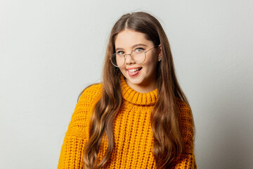 Beautiful girl in glasses and yellow sweater on white background