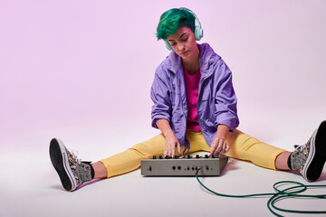 Content millennial woman in headphones playing on keyboard controller