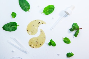 Hydrogel cosmetic moisturizing and refreshing collagen eye patches on white background with peppermint leaves and water drops