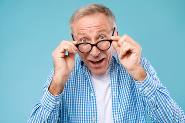Surprised mature man in glasses staring at camera - obrazy, fototapety, plakaty