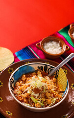 red pozole, with pork and vegetables, radish, onion, lettuce, served with toasted tortillas