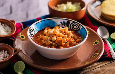 red pozole, with pork and vegetables, radish, onion, lettuce, served with toasted tortillas