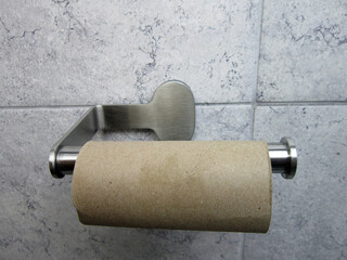   Out of Toilet Paper. Empty toilet paper roll on bathroom wall.  