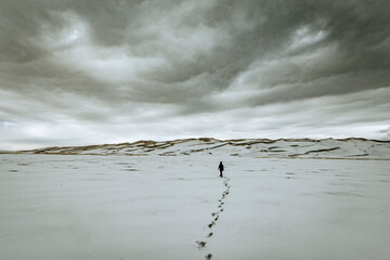 single person and footsteps clouds, sand dunes national park Colorado