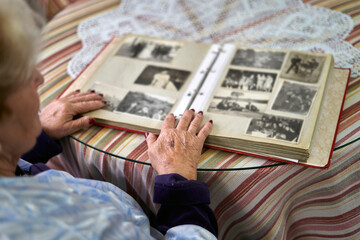 Unrecognizable senior woman watching an album of old photographs