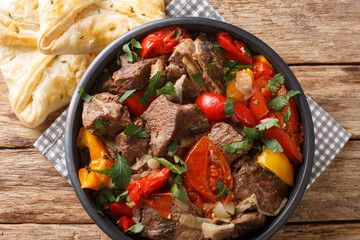 Buglama Traditional hot ragout with meat and vegetables closeup in the Bowl on the wooden table. Horizontal top view from above