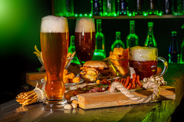 Mugs of green beer, ale on the bar counter. Holiday of Ireland on St. Patrick's Day in irish pub, bar. Festive Leprikon's green hat. National tradition of carnival celebrating March 17