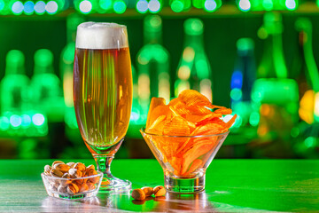 Mugs of green beer, ale on the bar counter. Holiday of Ireland on St. Patrick's Day in irish pub, bar. Festive Leprikon's green hat. National tradition of carnival celebrating March 17