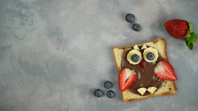 Kids breakfast or lunch or snack toast with chocolate hazelnut spread, banana, strawberry and blueberry shaped as cute owl. Children's food menu