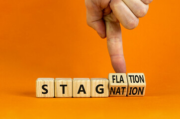 Stagflation or stagnation symbol. Businessman turns cubes, changes the word stagnation to...