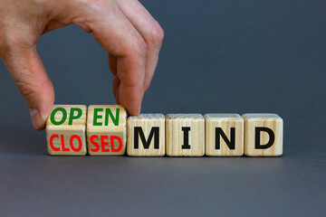 Open or closed mind symbol. Businessman turns cubes and changes concept words closrd mind to open mind. Beautiful grey table, grey background, copy space. Business open or closed mind concept.