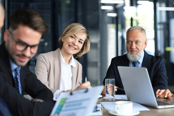 Group of business partners discussing ideas and planning work in office.