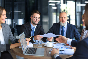 Team of business people having discussion at table in creative office.