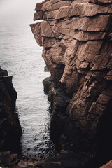 Rising tide waves crashing into a natural rock inlet called Thunder Hole in Acadia National Park,...