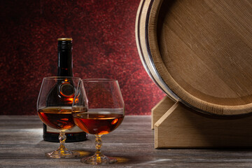 Whiskey barrel, bottle and glasses on wooden table