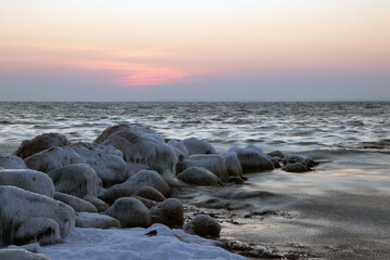 ice covered stones by the sea in winter.