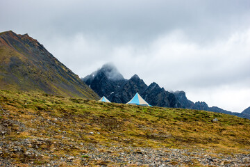 Travelling above the tree line in Alaska's Northern Talkeetna Mountains, a backpacking expedition relies on lightweight tarps and tents for shelter.