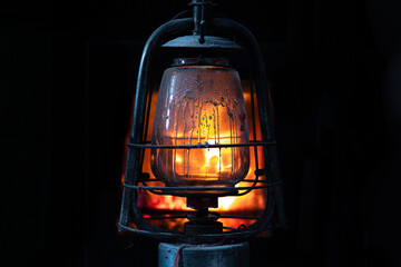 Vintage oil lamp.  Lantern in the dark room. Oil Lamp Lighting up the Darkness.