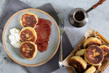 fried cottage cheese pancakeson on light background with grey textiles top view