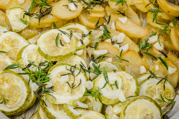 slices of freshly baked potatoes and zucchini with dill and garlic